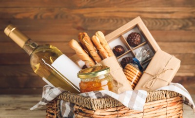 Gift basket with products on wooden background