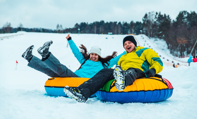 couple having fun slide down with snow tube. winter leisure