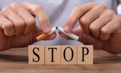 Man Breaking Cigarette Over Stop Wooden Blocks