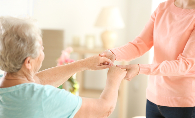 Old and young women holding hands on blurred background