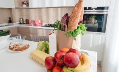 Paper bag with vegetables and some bread with copy space