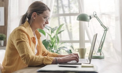 Young businesswoman sitting at desk and working from home, she is connecting with her laptop