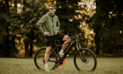 Handsome young man riding ebike in nature