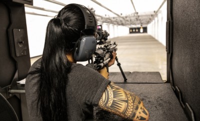 View of a young woman shooting a rifle on a stand at a shooting