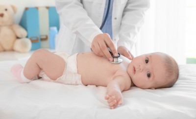 Doctor examining little baby with stethoscope in clinic. Baby health concept