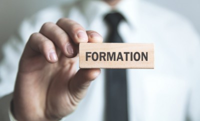 Businessman showing Formation word in wooden block.