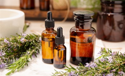 Rosemary essential oil on vintage apothecary bottles. Herbal oil for skin care, aromatherapy and natural medicine