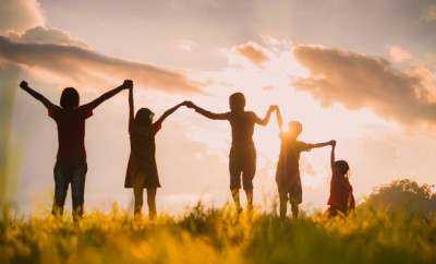 The silhouette of the children holding hands, enjoying the sunse