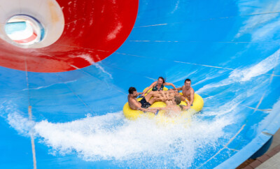 Frinds on big colorful water slide at aquapark